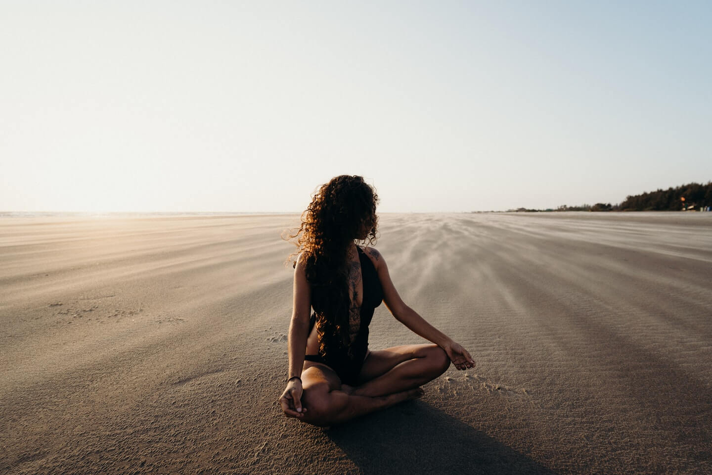 Yogini meditating on the beach in NZ